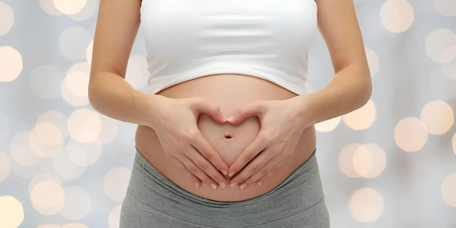 pregenant lady holding her stomach in a heart shape