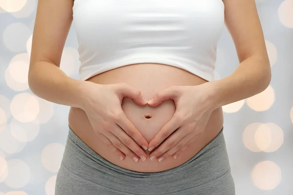 pregenant lady holding her stomach in a heart shape